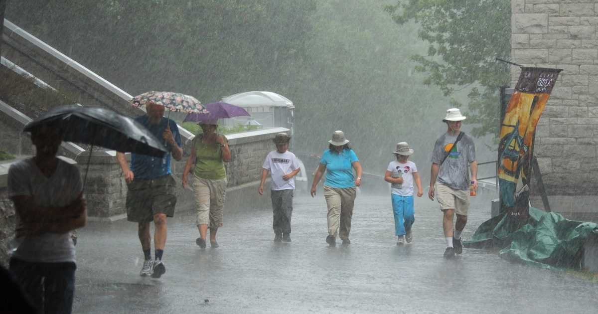 افرادی چتر به دست و بدون چتر زیر باران شدید